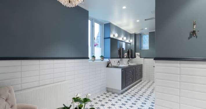 Toalett med hvite fliser og blå vegg.